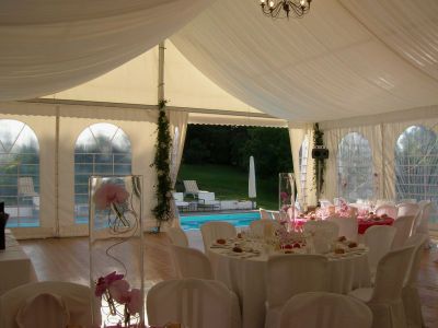 Intérieur 10m avec chaises houssée blanches et tables rondes